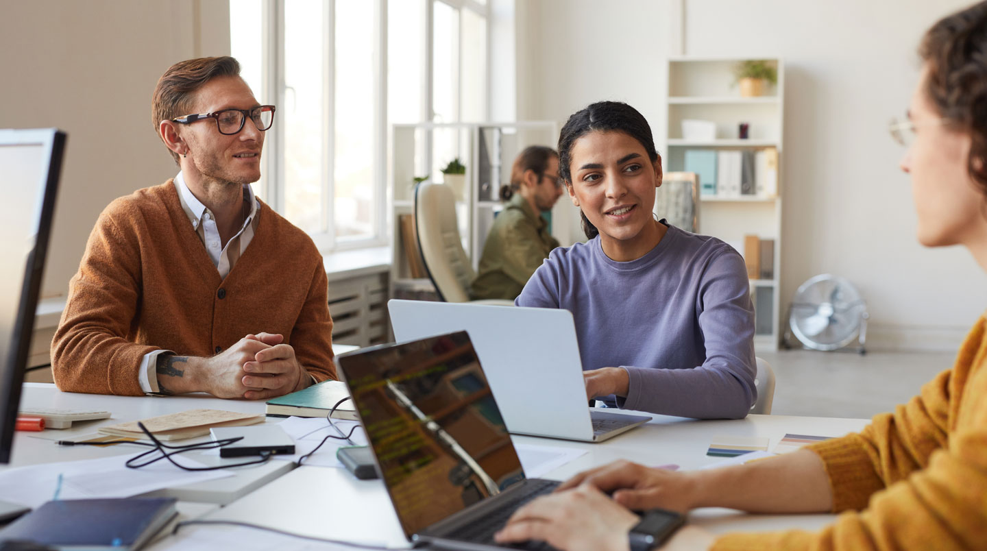 Gros plan sur des mains tapant sur un clavier d'ordinateur portable moderne avec des lignes de texte floues visibles à l'arrière-plan